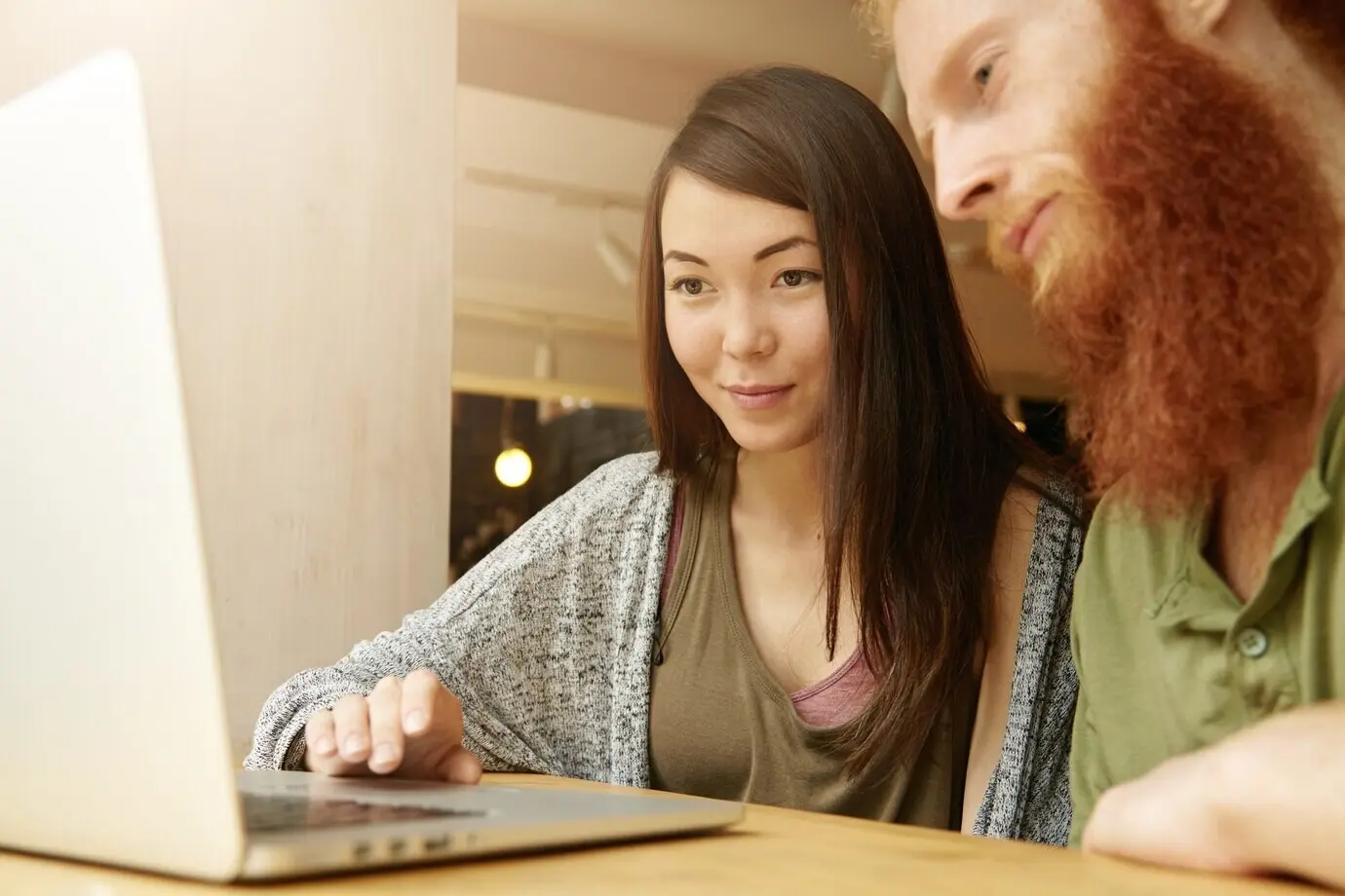 Eine brünette Frau und ein rothaariger Mann sitzen in einem Café.